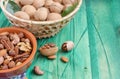 walnuts in a basket and nuts in a bowl on a green background of copi space