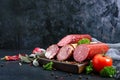 Several kinds of sausage, fresh vegetables and greens on a black background. Royalty Free Stock Photo