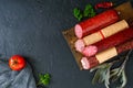 Several kinds of sausage, fresh vegetables and greens on a black background. Royalty Free Stock Photo