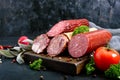 Several kinds of sausage, fresh vegetables and greens on a black background. Royalty Free Stock Photo