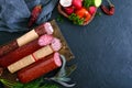 Several kinds of sausage, fresh vegetables and greens on a black background. Royalty Free Stock Photo