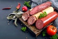 Several kinds of sausage, fresh vegetables and greens on a black background. Royalty Free Stock Photo