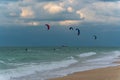 Several kite-surfers fighting with gusty windy weather and waves in the ocean. Amazing adventure and adrenaline sport