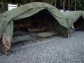 Several large military tents on the paved area