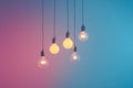 Several light bulbs in soft colors suspended from the ceiling creating a warm and cozy ambiance against a cool gradient backdrop Royalty Free Stock Photo