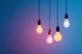 Several light bulbs in soft colors suspended from the ceiling creating a warm and cozy ambiance against a cool gradient backdrop Royalty Free Stock Photo