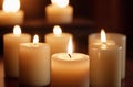 Several lighten candles on wooden surface on dark background Royalty Free Stock Photo