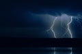 Several lightning strikes during a strong thunderstorm over the lake Royalty Free Stock Photo