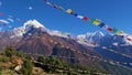 Several lines of Buddhist prayer flags flying in the wind above Namche Bazar, Khumbu, Himalayas, Nepal with mountain panorama.