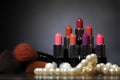 several lipstick brushes and various shades of pink on a dark table