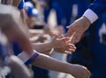 Several Little children giving high fives to their sports heroes outside of a sports arena as they walk by. Royalty Free Stock Photo