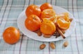 Several mandarins lie on a white dish