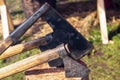 Several medieval ax iron black big thrust into a wooden log close up tool lumberjack