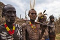 Several men from the Caro tribe pose in front of the camera for a group photo.