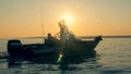 Several men with fishing rods are floating on an autoboat in sunlight