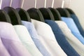 Several men`s shirts of different colors on the hangers. Selective focus. Royalty Free Stock Photo