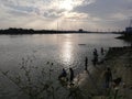 A group of people were fishing by the river at sunset