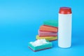 Several multi-colored foam sponges and cleaning agent on a blue background Royalty Free Stock Photo