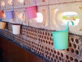 several multi-colored pots hanging on a brick wall