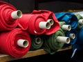 Several multi-colored rolls of knitted fabric. Woven factory or warehouse