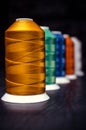 Several of multi-colored spools of threads. Perspective on a black background Royalty Free Stock Photo