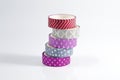 Several multicolored shiny rolls of adhesive packaging tape on a light background