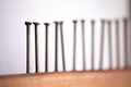 Several nails hammered into a wooden board close-up. The view is tilted focus Royalty Free Stock Photo