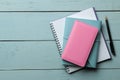 Several notebooks and pen on a light blue wooden table. top view. office tools Royalty Free Stock Photo