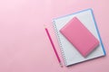 Several notebooks and a pink pencil on a bright pink background. top view. office tools Royalty Free Stock Photo