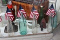 Several glass bottles with a small American flag sticking out in local antique shop, Saratoga, New York, 2018