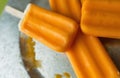 Several orange creamsicles on a galvanized steel plate. Close up view. Royalty Free Stock Photo