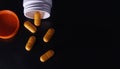 Several orange medical pills and tablets spilling out of a drug bottle Royalty Free Stock Photo