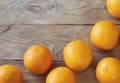 A few oranges, bright orange color on the old wooden background, brown color with a blurred background. Close-up.