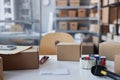 Several packed parcels, knife and cellotape on desk in storage room Royalty Free Stock Photo