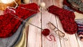 Several pairs of hand-knitted wool socks, knitting needles and tangles of yarn on a table