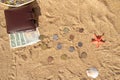 Several paper buy-to-let U.S. and Vietnamese lie on the sea sand under a brown wallet. Nearby coins of different countries are Royalty Free Stock Photo