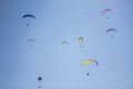 A several paragliders on colorful parachutes in a clear blue sky
