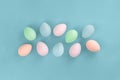 Several pastel color dyed easter eggs on duck egg blue