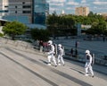 Several people in astronaut costumes stand on the stairs on the city street