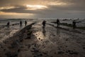 Several photographers `fish` photos on the rocky beach at sunset