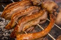 Several pieces of Liempo, or pork belly skewered on a spit and roasted on an oven at a roadside restaurant