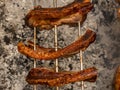 Several pieces of Liempo, or pork belly skewered on a spit and roasted on an oven at a roadside restaurant