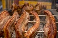 Several pieces of Liempo, or pork belly skewered on a spit and roasted on an oven at a roadside restaurant. Lechon manok in the