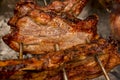 Several pieces of Liempo, or pork belly skewered on a spit and roasted on an oven at a roadside restaurant