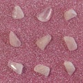 Several pieces of polished pink quartz on glitter pink background. Minimal color still life photography Royalty Free Stock Photo