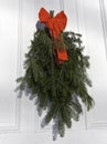 Pine and fir boughs on door with red ribbon Royalty Free Stock Photo