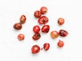 Several pink peppercorns Baie rose on gray
