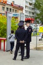 Several police officers works in control through the frame of a metal detector on a holiday in the city.