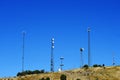 Several Radio Towers on Top of Hill with Blue Sky