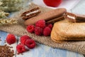 Several raspberries next to creame biscuits